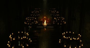 Movie still from “Immortals” (2011), directed by Tarsem Singh – Candles are lit in the dark in a church; Extreme Wide shot, High angle
