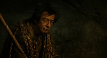 Movie still from “Immortals” (2011), directed by Tarsem Singh – An older man wearing a fur coat looking at the camera; Close Up shot, Over the shoulder angle