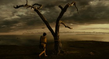 Movie still from “Immortals” (2011), directed by Tarsem Singh – A man is standing in front of a dead tree; Extreme Wide shot, High angle
