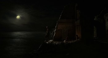 Movie still from “Immortals” (2011), directed by Tarsem Singh – Two people are standing in the dark in front of a building; Extreme Wide shot, High angle