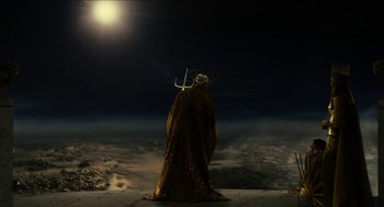Movie still from “Immortals” (2011), directed by Tarsem Singh – A man in a costume standing on a hill at night; Wide shot, High angle