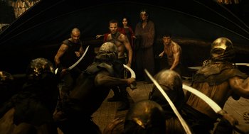 Movie still from “Immortals” (2011), directed by Tarsem Singh – A group of people are fighting with swords in a cave; Wide shot, Over the shoulder angle