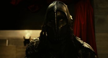 Movie still from “Immortals” (2011), directed by Tarsem Singh – A person wearing a black mask and a black helmet; Close Up shot, Low angle