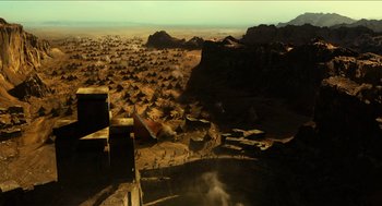 Movie still from “Immortals” (2011), directed by Tarsem Singh – An aerial view of a desert area with mountains in the background; Extreme Wide shot, High angle