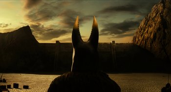 Movie still from “Immortals” (2011), directed by Tarsem Singh – A statue of an animal with horns on it's head in front of a sunset; Extreme Wide shot, High angle