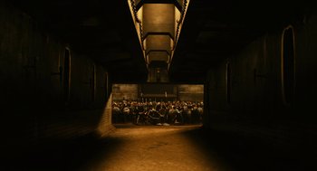 Movie still from “Immortals” (2011), directed by Tarsem Singh – A group of people sitting on the ground in a tunnel; Extreme Wide shot, High angle