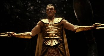 Movie still from “Immortals” (2011), directed by Tarsem Singh – A statue of a man wearing a gold costume; Medium shot, Low angle