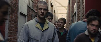 Movie still from “In Time” (2011), directed by Andrew Niccol – A group of young men walking down a brick alley; Close Up shot, Low angle