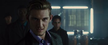 Movie still from “In Time” (2011), directed by Andrew Niccol – A man in a suit and tie standing next to another man in a suit; Close Up shot, Over the shoulder angle