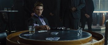 Movie still from “In Time” (2011), directed by Andrew Niccol – A man sitting at a table in front of playing cards; Medium shot, Over the shoulder angle