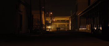 Movie still from “In Time” (2011), directed by Andrew Niccol – Two people walking down a street at night; Extreme Wide shot, High angle