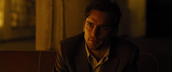 Movie still from “In Time” (2011), directed by Andrew Niccol – A person wearing a suit and tie; Close Up shot, Over the shoulder angle