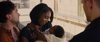 Movie still from “In Time” (2011), directed by Andrew Niccol – A woman holding a baby in her arms and smiling; Close Up shot, Over the shoulder angle