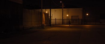 Movie still from “In Time” (2011), directed by Andrew Niccol – A person is walking in the dark at night; Extreme Wide shot, High angle