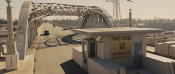 Movie still from “In Time” (2011), directed by Andrew Niccol – A view of a bridge that has a sign on it; Extreme Wide shot, High angle