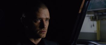 Movie still from “In Time” (2011), directed by Andrew Niccol – A person holding a gun in the dark; Close Up shot, Over the shoulder angle