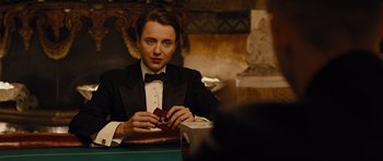 Movie still from “In Time” (2011), directed by Andrew Niccol – A man sitting at a table in a suit and bow tie; Close Up shot, Over the shoulder angle