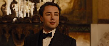 Movie still from “In Time” (2011), directed by Andrew Niccol – A person wearing a suit and a bow tie; Close Up shot, Low angle