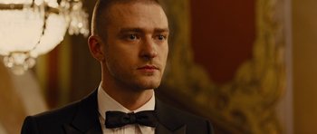 Movie still from “In Time” (2011), directed by Andrew Niccol – A person wearing a suit and bow tie; Close Up shot, Over the shoulder angle