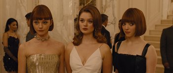 Movie still from “In Time” (2011), directed by Andrew Niccol – A woman in a white dress standing in front of other women; Medium shot, Over the shoulder angle