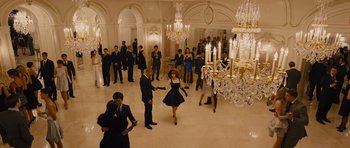 Movie still from “In Time” (2011), directed by Andrew Niccol – A group of people standing in a room with chandeliers; Wide shot, High angle