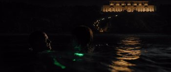 Movie still from “In Time” (2011), directed by Andrew Niccol – A person swimming in a body of water at night; Extreme Wide shot, High angle
