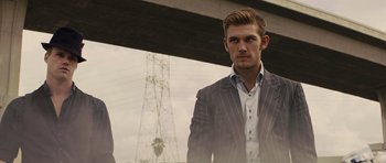 Movie still from “In Time” (2011), directed by Andrew Niccol – A man in a suit standing next to an electrical tower; Close Up shot, Low angle