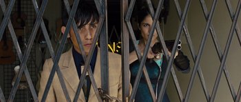 Movie still from “In Time” (2011), directed by Andrew Niccol – A man and a woman behind a gate; Medium shot, Low angle