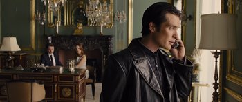 Movie still from “In Time” (2011), directed by Andrew Niccol – A man and a woman in a room with a fireplace; Medium shot, Over the shoulder angle