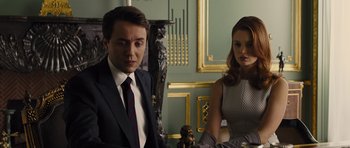 Movie still from “In Time” (2011), directed by Andrew Niccol – A man and a woman sitting next to each other in a room; Medium shot, Over the shoulder angle