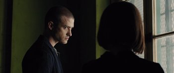 Movie still from “In Time” (2011), directed by Andrew Niccol – A man standing next to a woman in a dark room; Close Up shot, Over the shoulder angle