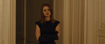 Movie still from “In Time” (2011), directed by Andrew Niccol – A woman in a black dress and black gloves; Medium shot, Low angle