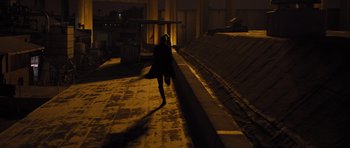 Movie still from “In Time” (2011), directed by Andrew Niccol – A woman walking down a sidewalk at night; Extreme Wide shot, High angle