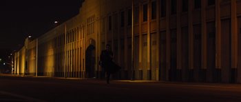Movie still from “In Time” (2011), directed by Andrew Niccol – A man running in the dark on a street at night; Extreme Wide shot, Low angle