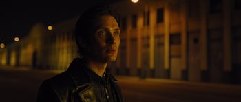 Movie still from “In Time” (2011), directed by Andrew Niccol – A man in a leather jacket is standing in the dark; Close Up shot, Low angle