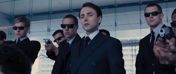 Movie still from “In Time” (2011), directed by Andrew Niccol – A group of men standing next to each other wearing suits; Close Up shot, Low angle