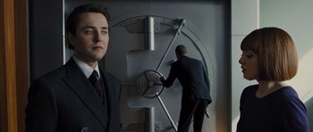 Movie still from “In Time” (2011), directed by Andrew Niccol – A man in a business suit and a man in a business suit and a man in a business suit; Medium shot, Low angle