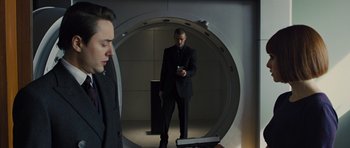 Movie still from “In Time” (2011), directed by Andrew Niccol – A man in a suit is looking at his cell phone; Medium shot, Low angle