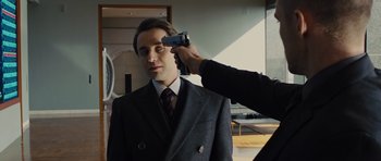 Movie still from “In Time” (2011), directed by Andrew Niccol – A man in a suit and tie taking a picture of another man in a suit and tie; Close Up shot, Over the shoulder angle