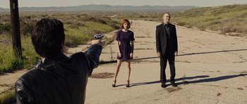 Movie still from “In Time” (2011), directed by Andrew Niccol – A man taking a picture of a woman and a man in a suit; Wide shot, Over the shoulder angle