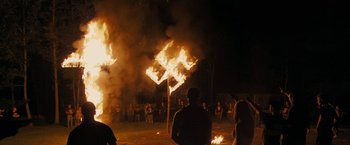 Movie still from “Imperium” (2016), directed by Daniel Ragussis – People standing in front of a burning building; Extreme Wide shot, High angle