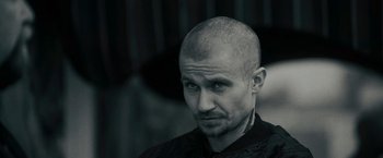 Movie still from “Imperium” (2016), directed by Daniel Ragussis – A man with a shaved head is looking at the camera; Close Up shot, Low angle