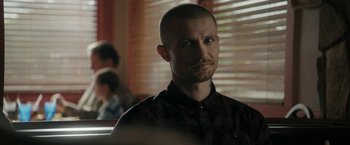Movie still from “Imperium” (2016), directed by Daniel Ragussis – A man with a shaved head is looking at the camera; Close Up shot, Over the shoulder angle