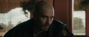 Movie still from “Imperium” (2016), directed by Daniel Ragussis – A man with a shaved head and a beard; Close Up shot, Over the shoulder angle