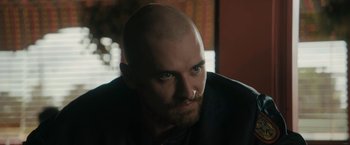 Movie still from “Imperium” (2016), directed by Daniel Ragussis – A man with a shaved head and a mustache; Close Up shot, Over the shoulder angle