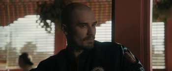 Movie still from “Imperium” (2016), directed by Daniel Ragussis – A man with a shaved head looking to his left; Close Up shot, Over the shoulder angle