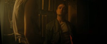 Movie still from “Imperium” (2016), directed by Daniel Ragussis – A man in a dark room with his eyes wide open; Medium shot, Low angle