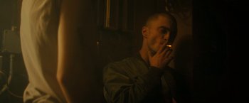 Movie still from “Imperium” (2016), directed by Daniel Ragussis – A man is smoking a cigarette in a dark room; Close Up shot, Over the shoulder angle