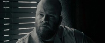 Movie still from “Imperium” (2016), directed by Daniel Ragussis – Black and white photograph of a man with a goatee; Close Up shot, Low angle