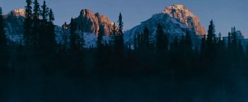 Movie still from “Imperium” (2016), directed by Daniel Ragussis – A view of a mountain range at dusk with trees in the foreground; Extreme Wide shot, Low angle